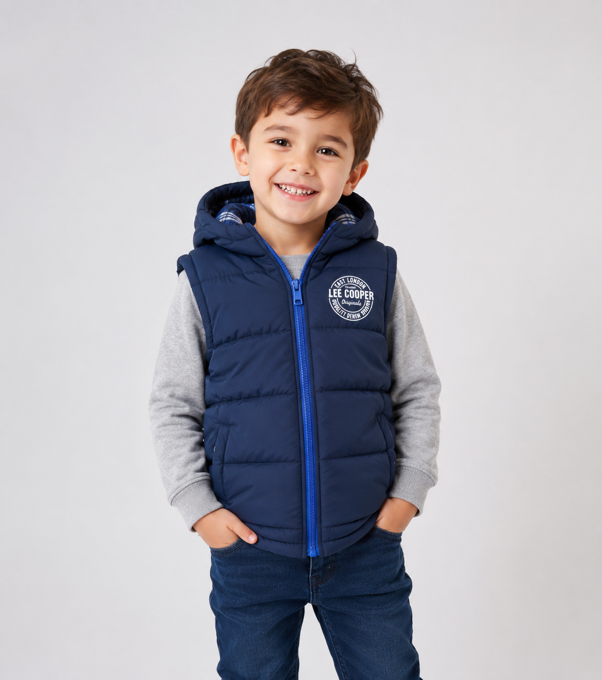  East London Kids Hooded Puffer Gilet in navy blue. Lightweight, warm, and stylish sleeveless winter vest with hood, zip closure, and practical pockets for everyday comfort.
