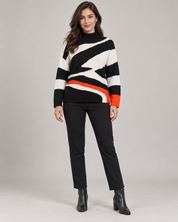   Little Miss black, white and orange geometric knit jumper in UK Size M. Warm high-neck design with bold contrast detailing, perfect for everyday winter styling.
