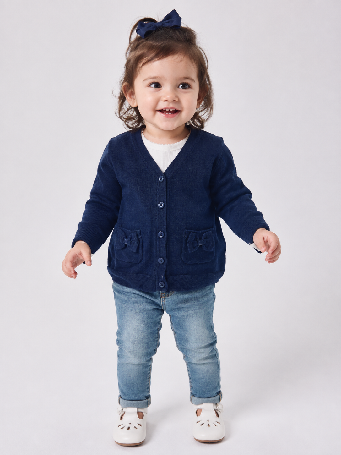  Next baby girls’ navy blue knitted cardigan in UK size 1–1.5 years. Features bow pockets, V-neck, button fastening and cosy long sleeves.