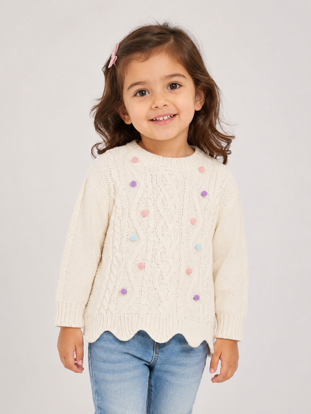  Primark girls’ cream cable knit sweater with pastel pom-pom details, long sleeves and scalloped hem. UK size 3-4 years.